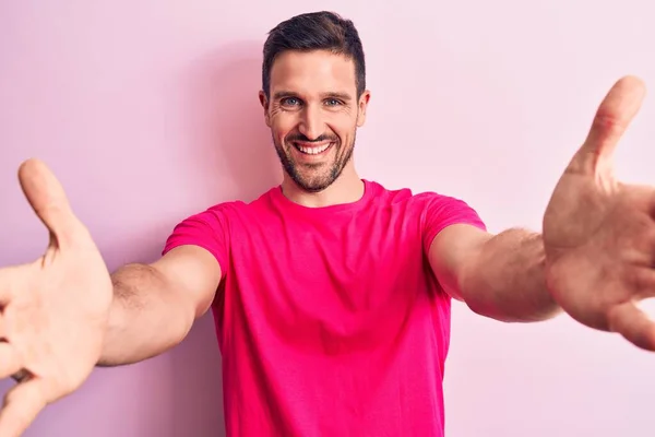 Joven Hombre Guapo Con Camiseta Casual Pie Sobre Fondo Rosa —  Fotos de Stock