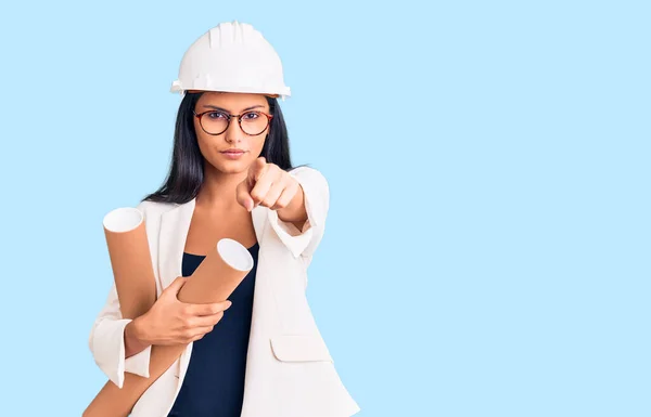 Jovem Bela Menina Latina Vestindo Arquiteto Hardhat Segurando Plantas Apontando — Fotografia de Stock