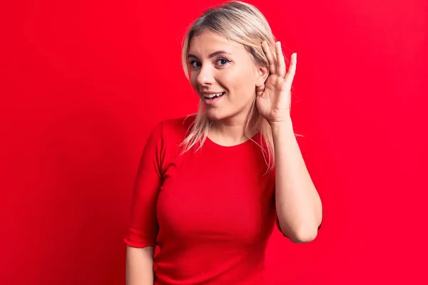 Młoda Piękna Blondynka Ubrana Luźny Czerwony Shirt Stojąca Nad Odosobnionym — Zdjęcie stockowe