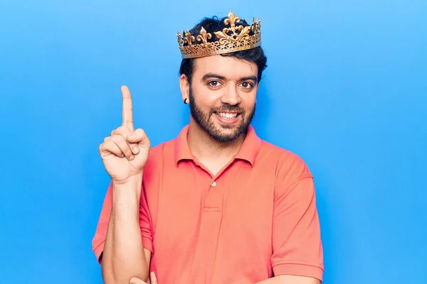 Mladý Hispánec Koruně Krále Usmívající Nápadem Nebo Otázkou Ukazující Prstem — Stock fotografie