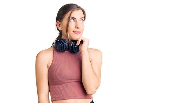 Όμορφη Καυκάσια Νεαρή Γυναίκα Φορώντας Ρούχα Γυμναστικής Και Χρησιμοποιώντας Ακουστικά — Φωτογραφία Αρχείου