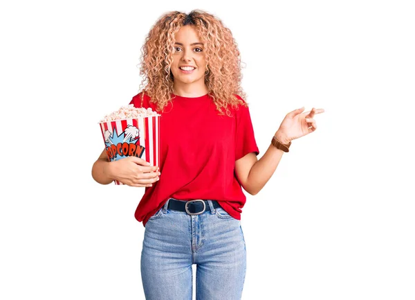 Jovem Loira Com Cabelo Encaracolado Comendo Pipoca Sorrindo Feliz Apontando — Fotografia de Stock