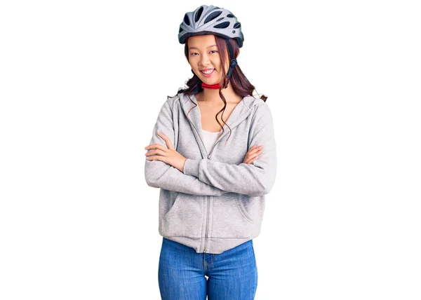 年轻美丽的中国姑娘戴着自行车头盔 笑容满面 交叉着双臂看着相机 积极的人 — 图库照片