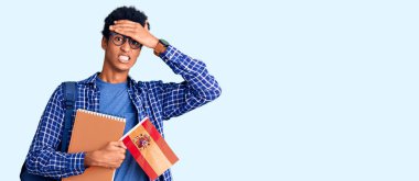 İspanyol bayrağı taşıyan öğrenci çantası taşıyan Afro-Amerikalı genç bir adam kafa kafaya, şaşırmış ve kızgın bir yüzle stresli ve hayal kırıklığına uğramış. 