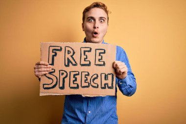 Genç, yakışıklı, kızıl saçlı, özgürlük isteyen özgür konuşma mesajıyla pankart tutan, ağzı açık, korkmuş, şaşırmış, imansız bir adam.