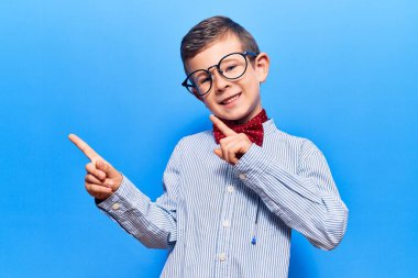 İnek papyonu takan, gözlüklü, gülümseyen ve kameraya bakan sevimli sarışın çocuk.. 