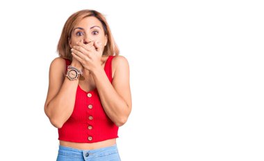 Gündelik kıyafetler giyen genç sarışın kadın yanlışlıkla elleri ile ağzını kapatırken şok oldu. gizli kavram. 