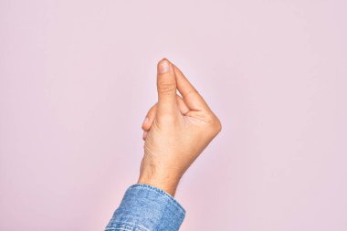 İzole edilmiş pembe arka planda parmaklarını gösteren beyaz bir gencin eli parmak, iş ve reklamla boş bir alan tutuyor.