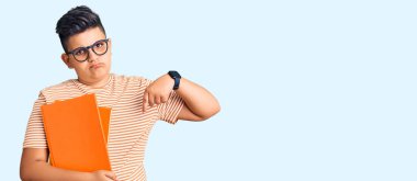 Küçük çocuk elinde gözlük takmış üzgün üzgün bakıyor, parmaklarıyla yön gösteriyor, mutsuz ve depresif.. 