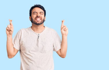 Günlük kıyafetler giyen genç İspanyol adam umut ve gözlerin kapalı gülümseyerek bana işaret etti. Şans ve batıl inançlar. 