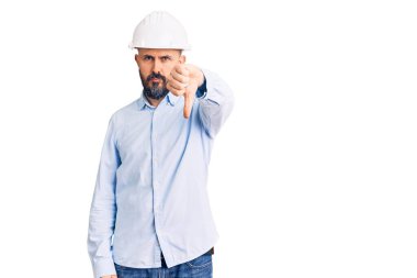 Mimar şapkası takan genç yakışıklı adam mutsuz görünüyor ve reddediliyor ve olumsuz bir hareket yapıyor. kötü ifade. 