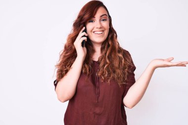 Genç ve güzel bir kadın akıllı telefonda konuşuyor zaferi mutlu bir gülümsemeyle kutluyor ve kazanan el kaldırarak ifade ediyor. 