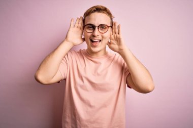Genç, yakışıklı, günlük tişört giyen, pembe arka planda dikilen neşeli gülümseyen, elleri havada dikizleme oyunu oynayan bir kızıl adam. Şaşırdım ve çıktım.