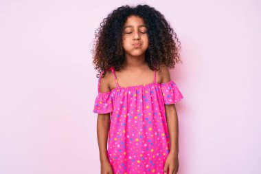 Kıvırcık saçlı, sıradan giyinmiş, komik yüzlü Afro-Amerikalı çocuk. Havayla şişmiş ağız, çılgın bir ifade.. 