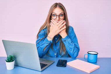 Ofiste çalışan genç sarışın kız bir fincan kahve içerken yanlışlıkla ağızlarını kapatarak şok geçirdi. gizli kavram. 