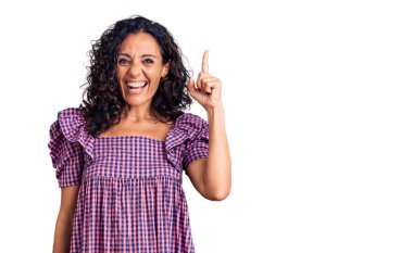 Orta yaşlı, gündelik elbise giyen güzel bir kadın başarılı bir fikri işaret ediyor. Heyecanlı ve mutlu. Bir numara.. 