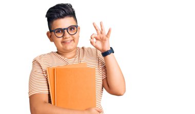 Gözlüklü, gülümseyen küçük çocuk el ve parmaklarıyla tamam işareti yapıyor. başarılı ifade. 