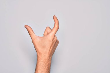 İzole edilmiş beyaz arka plan üzerinde parmaklarını gösteren beyaz bir adamın eli. Görünmez bir şeyi alıp, parmaklarıyla uzayı gösteren bir nesneyi tutuyor.