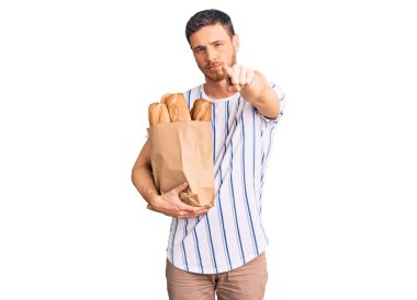 Elinde ayı çantasıyla yakışıklı genç bir adam kamerayı işaret eden bir ekmek ve sen, kendine güvenen ciddi görünüyorsun. 