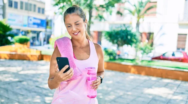 Parkta Akıllı Telefon Kullanarak Gülümseyen Orta Yaşlı Sporcu Kadın — Stok fotoğraf