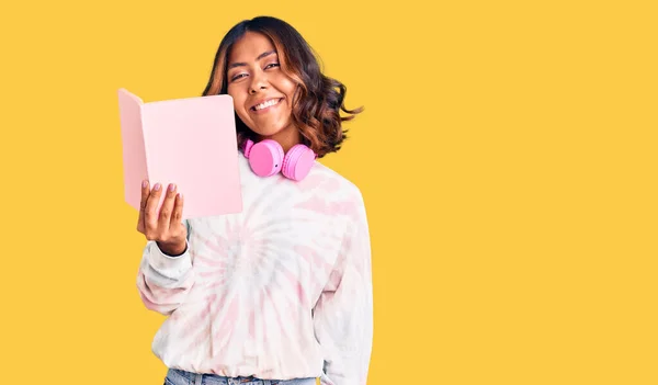 Jovem Bela Mulher Raça Mista Lendo Livro Usando Fones Ouvido — Fotografia de Stock