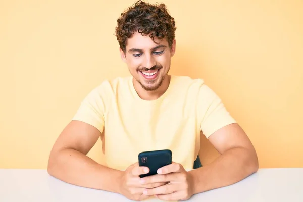 Giovane Uomo Caucasico Con Capelli Ricci Utilizzando Smartphone Seduto Sul — Foto Stock