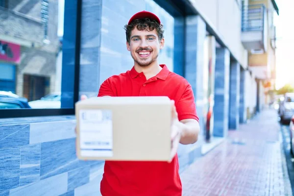 Jovem Homem Entrega Caucasiano Sorrindo Feliz Segurando Pacote Papelão Andando — Fotografia de Stock