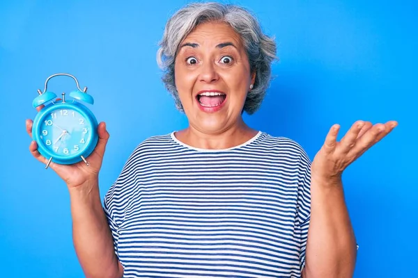 Ältere Hispanische Frau Mit Wecker Feiert Leistung Mit Glücklichem Lächeln — Stockfoto