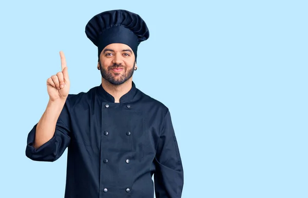 Young Hispanic Man Wearing Cooker Uniform Showing Pointing Finger Number — Stock Photo, Image