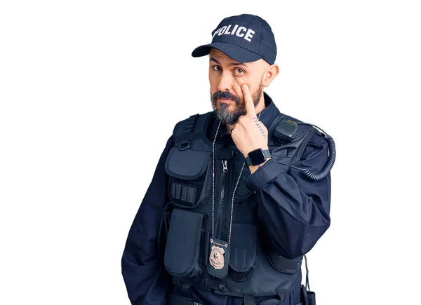 警察の制服を着た若いハンサムな男があなたがジェスチャーを見ているのを見て 怪しい表情 — ストック写真
