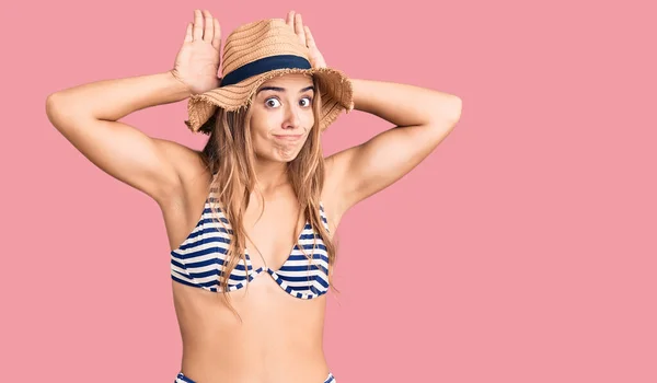 Fiatal Gyönyörű Szőke Bikiniben Kalapban Nyuszifüleket Gesztikulál Kezével Cinikusnak Szkeptikusnak — Stock Fotó