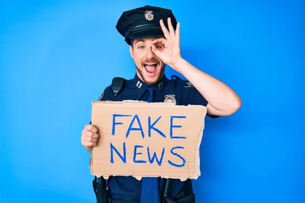 Junger Kaukasischer Mann Polizeiuniform Mit Fake News Banner Lächelnd Glücklich — Stockfoto