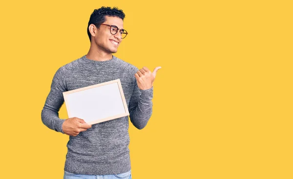 Hispanic Handsome Young Man Holding Blank Empty Banner Pointing Thumb — ストック写真