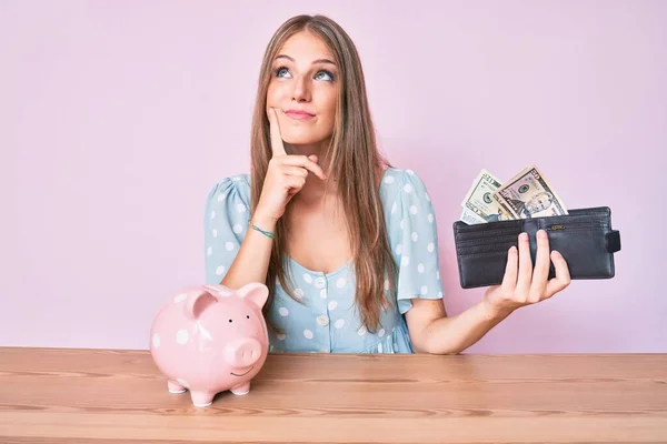 Jong Blond Meisje Houden Portemonnee Met Dollars Spaarvarken Bank Zitten — Stockfoto