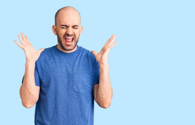 Gündelik tişört giyen genç yakışıklı adam başarı için deli ve çılgınlığı kutluyor kollarını kaldırmış ve gözlerini kapatmış heyecanla bağırıyor. Kazanan konsept 