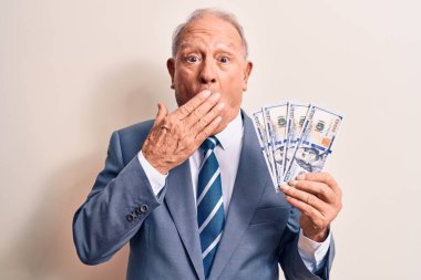 Kıdemli, gri saçlı, takım elbiseli bir iş adamı elinde bir deste dolarla ağzı ağızla kapatıyor, şok geçiriyor ve hata yapmaktan korkuyor. Şaşırtıcı ifade.