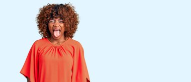 Genç Afro-Amerikan kadın, günlük kıyafetler giyip, dillerini komik bir ifadeyle dışarı çıkarıyor. duygu kavramı. 