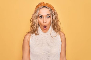 Güzel sarışın kadın, günlük tişört giyip sarı arka planda dolaşırken korku, korku ve heyecan dolu bir yüz ifadesiyle dehşete düşmüş ve şok olmuştu..