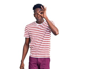 Genç Afro-Amerikan bir adam günlük giysiler giyiyor. Şaşırmış yüz ifadesiyle şaşırmış, parmaklarının arasından bakıyor. İnançsız ifade. 