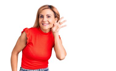 Gündelik kıyafetler giyen genç sarışın kadın kulağına fısıldayarak dedikoduları ve dedikoduları dinliyor. Sağırlık kavramı. 