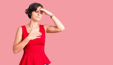 Kısa saçlı güzel bir kadın kolsuz gömlekli hastalık, ateş, grip ve virüs için alnına dokunuyor. 