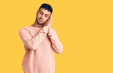 Gündelik kıyafetler giyen genç İspanyol adam uyur. Yorgun düşler kurar, ellerle poz verir, gözleri kapalı gülümserdi.. 