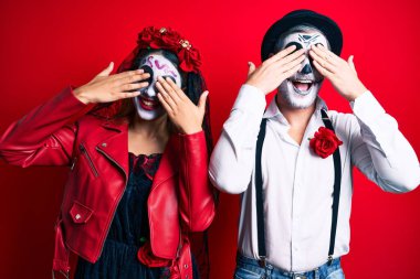 Ölü kostümün giyildiği gün kırmızı gözleri kaplayan neşeli ve komik elleri olan bir çift. kör kavram. 