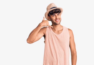 Yazlık şapkalı, gülümseyen, el ve parmaklarıyla telefonla konuşan İspanyol bir adam. iletişim kavramları. 