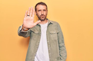 Sıradan kıyafetler giyen genç yakışıklı bir adam avucunun içi gibi şarkı söylemeyi kesiyor. Yüzünde olumsuz ve ciddi bir jest olan uyarı ifadesi. 