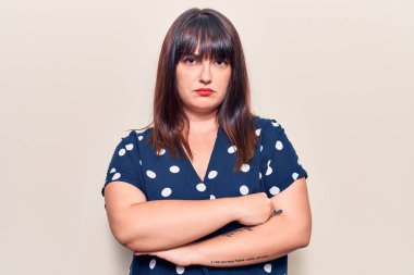 Sıradan giyinen, kuşkucu ve gergin genç ve cüsseli bir kadın. Yüzünde çapraz kollu tasvip etmeyen bir ifade. negatif kişi. 