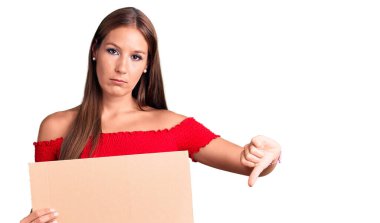 Genç, güzel İspanyol bir kadın elinde kızgın yüzlü pankart tutuyor. Negatif işaretler baş parmakları aşağıda, reddedilme konsepti reddediyor. 