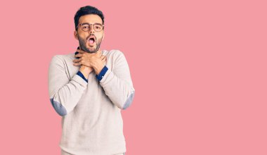 Zarif kıyafetler ve gözlük takmış genç yakışıklı İspanyol adam bağırıyor ve boğuluyor çünkü acı verici bir boğulma var. Sağlık problemi. Boğulma ve intihar konsepti. 