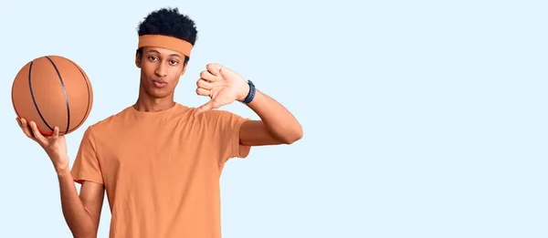 Joven Hombre Afroamericano Sosteniendo Pelota Baloncesto Con Cara Enojada Signo — Foto de Stock