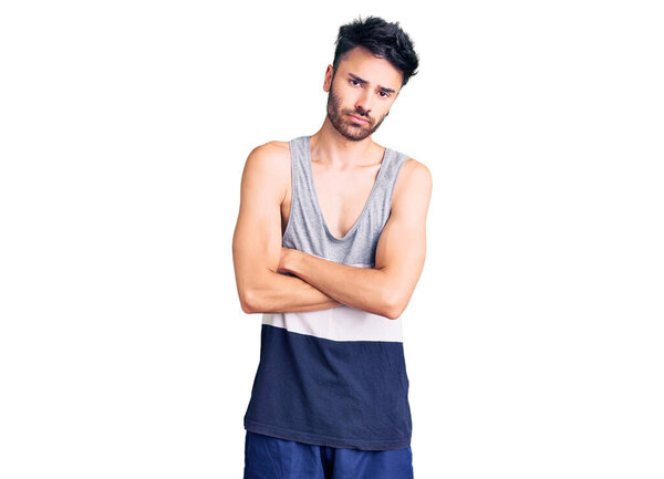 Молодой латиноамериканец в обычной одежде скептик и нервный, неодобрительное выражение лица со скрещенными руками. отрицательный человек. 